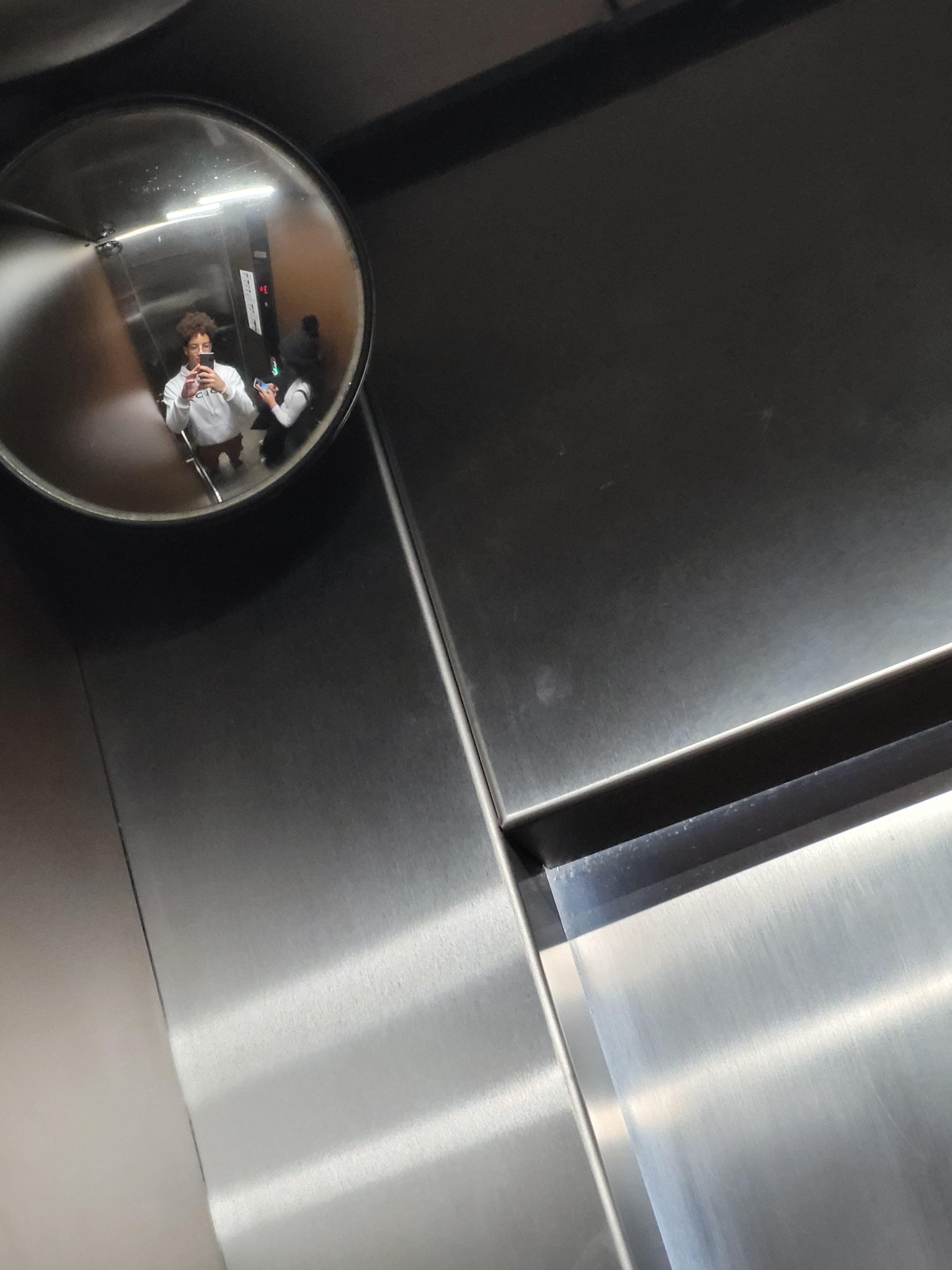 Distorcidos no canto de um elevador, ela nem liga.